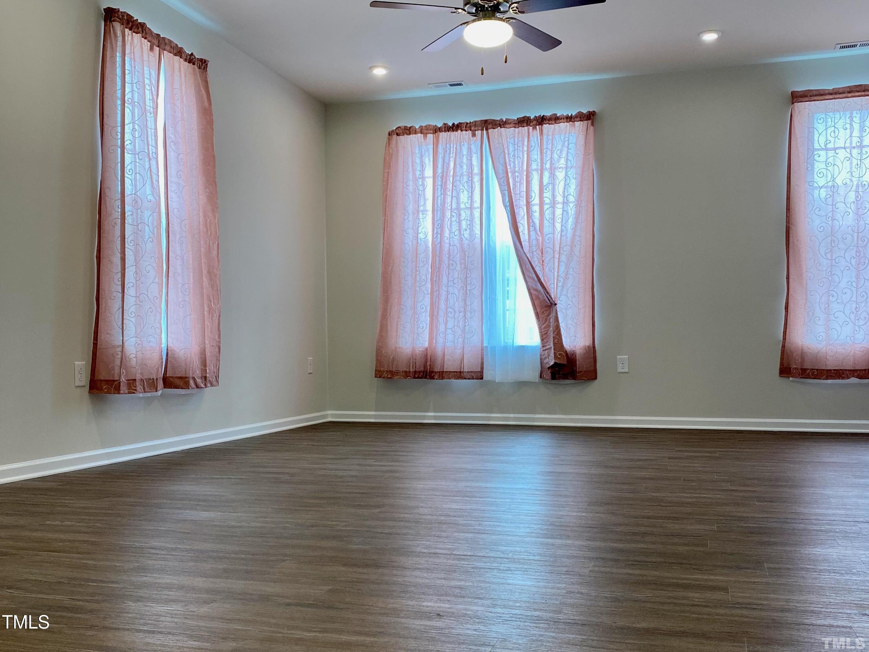 6627 Pathfinder Way Raleigh, NC 27616 - Photo 21 of 35 an empty room with wooden floor and windows