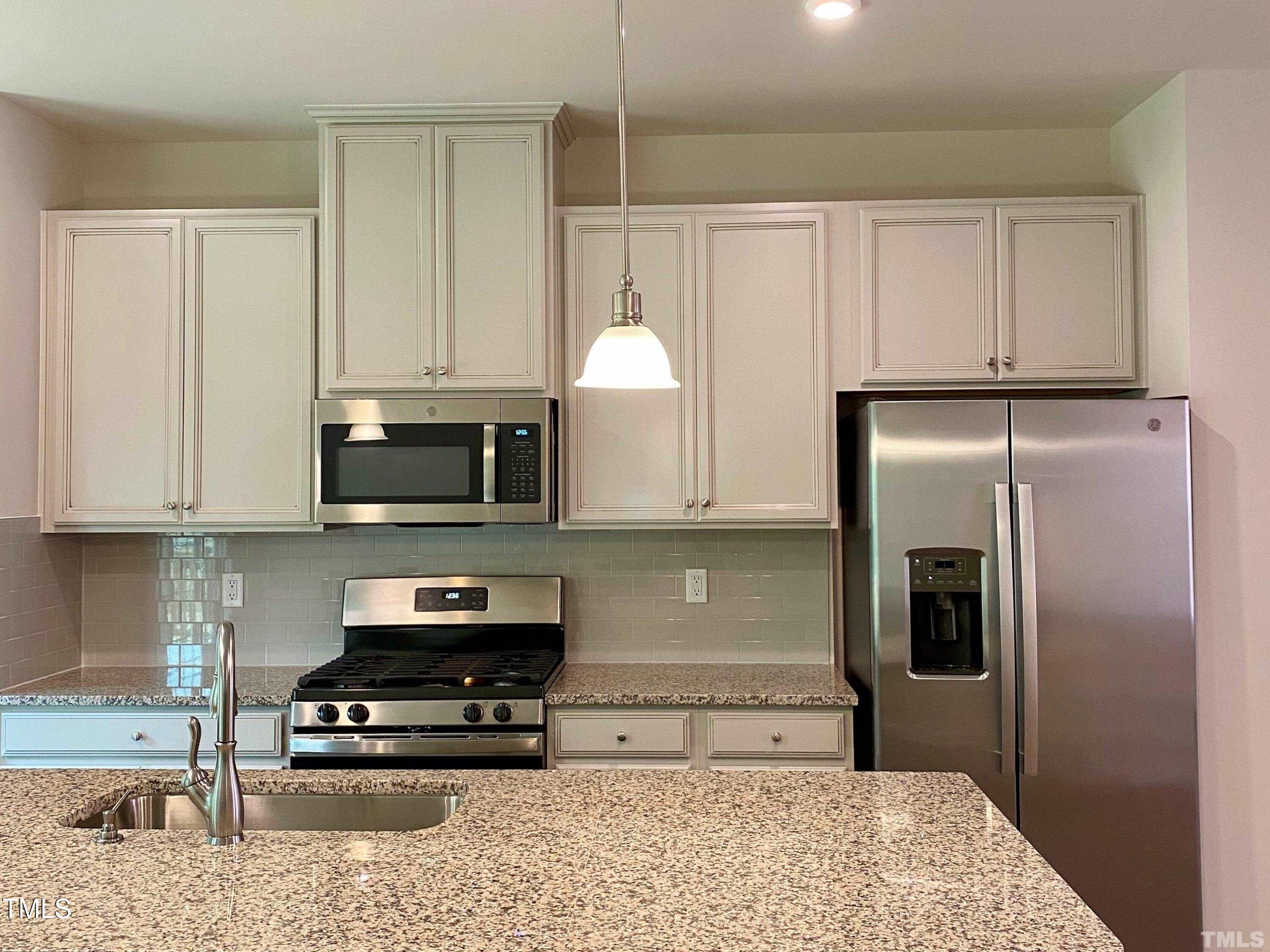 6627 Pathfinder Way Raleigh, NC 27616 - Photo 6 of 35 a kitchen with stainless steel appliances granite countertop a refrigerator a stove and a sink