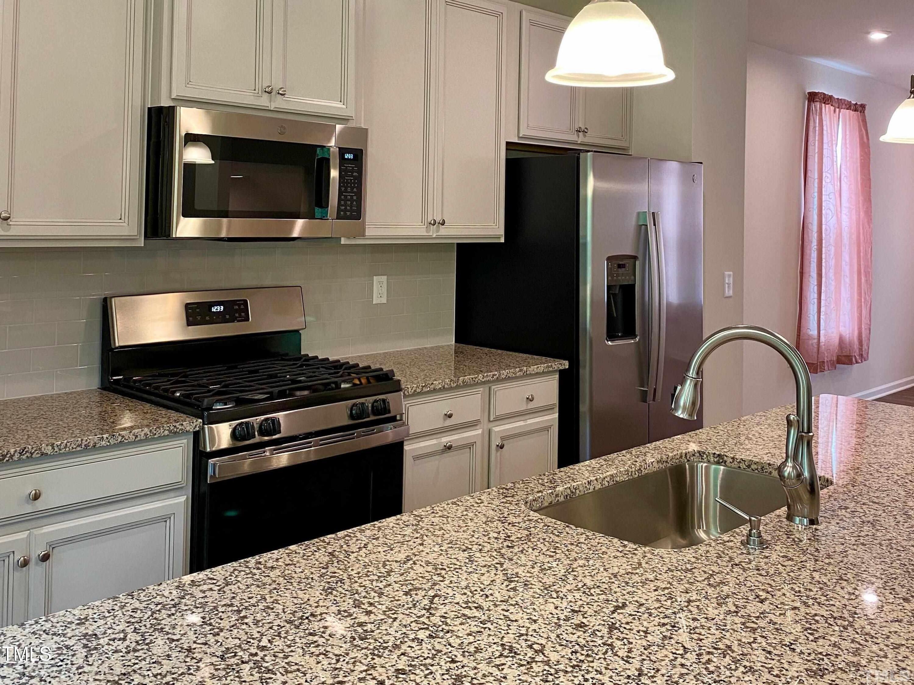 6627 Pathfinder Way Raleigh, NC 27616 - Photo 8 of 35 a kitchen with a stove a sink and a refrigerator