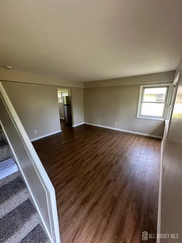 a view of a room with wooden floor and window
