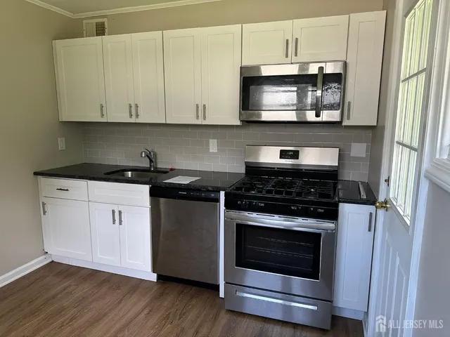 a kitchen with stainless steel appliances granite countertop a stove a microwave and cabinets