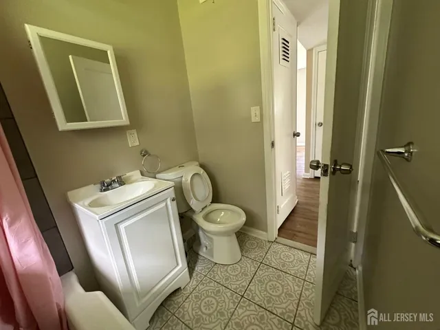 a bathroom with a granite countertop toilet a sink and a mirror
