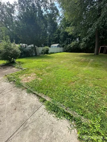 a view of a big yard with large trees