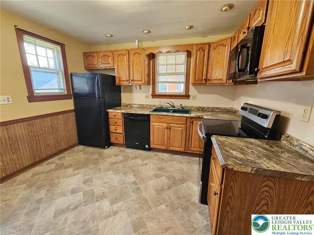 a kitchen with stainless steel appliances granite countertop a stove a sink dishwasher and a refrigerator