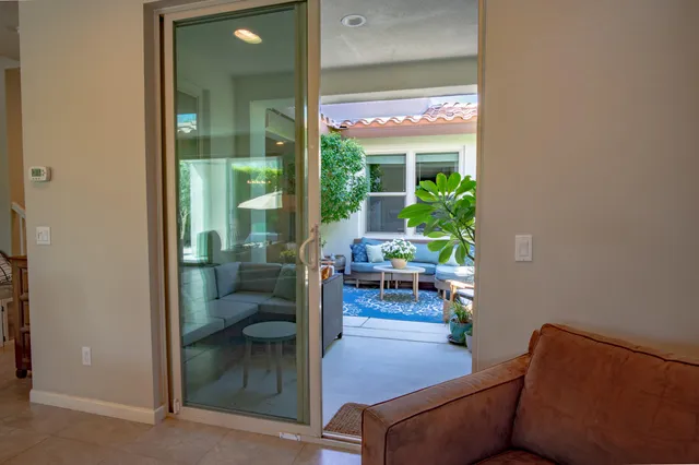 a living room with furniture a flat screen tv and a floor to ceiling window