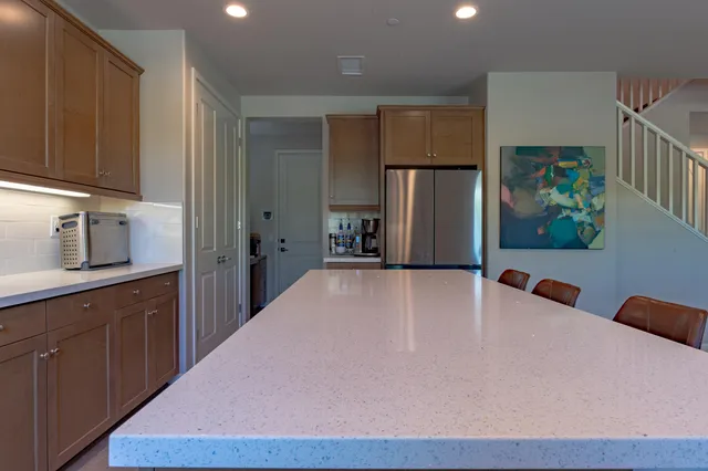 a kitchen with kitchen island granite countertop a sink a counter top space appliances and a center island