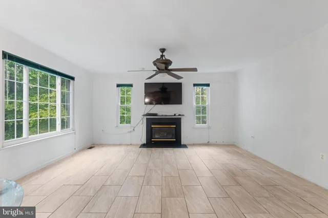a view of empty room with a fireplace and windows