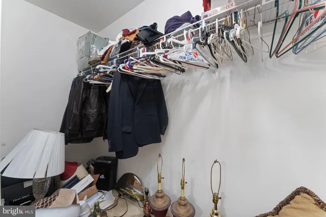 a view of walk in closet with clothes and shoes