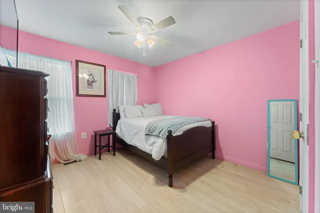 a bedroom with a bed dresser and a chandelier