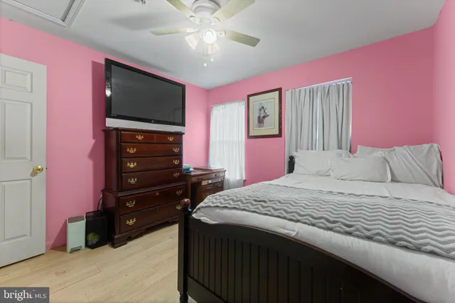 a bedroom with a bed dresser and a flat screen tv