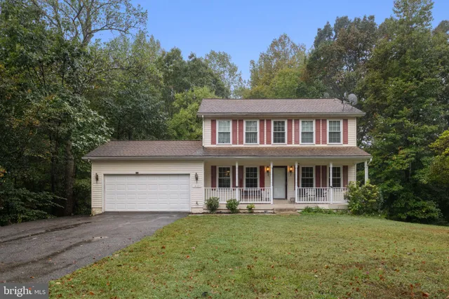 a front view of a house with a yard and trees