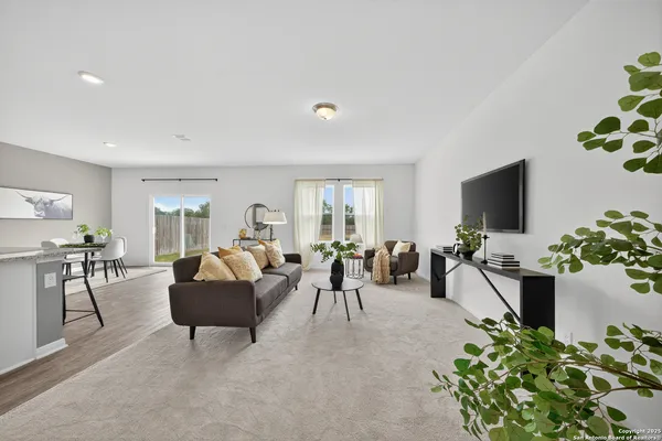 a living room with furniture a flat screen tv and a potted plant
