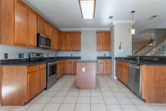 a kitchen with stainless steel appliances granite countertop a stove a sink and a microwave