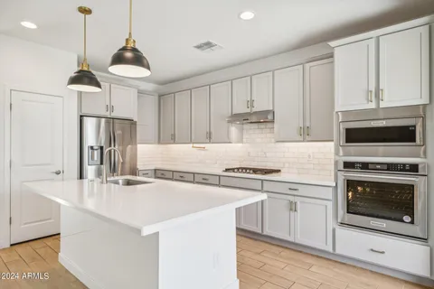 a kitchen with stainless steel appliances a stove a sink and a refrigerator