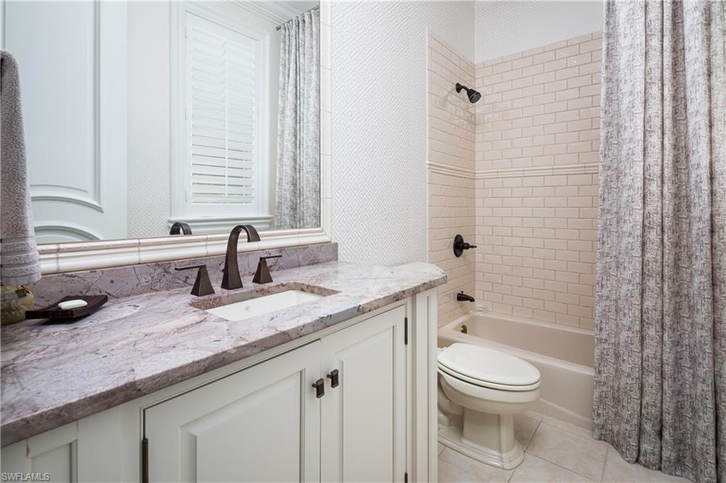 2145 Canna Way Naples, FL 34105 - Photo 34 of 49 a bathroom with a granite countertop toilet a sink and a bathtub