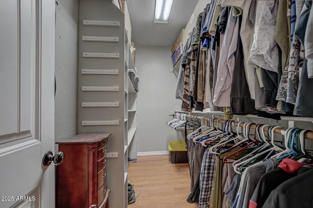 a view of walk in closet with clothes and shoes
