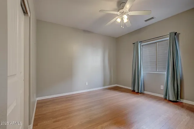 a view of a room with a ceiling fan and a hardwood floor
