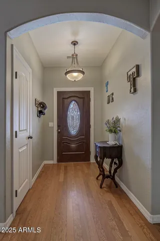 a view of a hallway with wooden floor and a chandelier