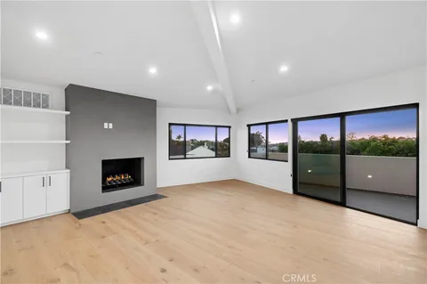 a view of an empty room with a fireplace and a window