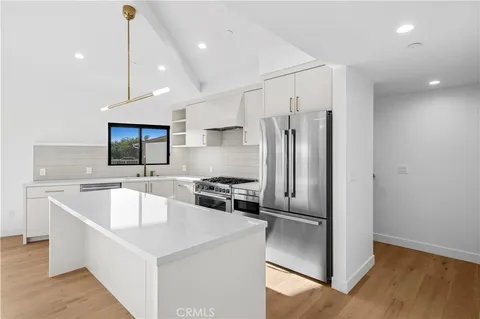a kitchen with stainless steel appliances a refrigerator a sink a stove a microwave and island