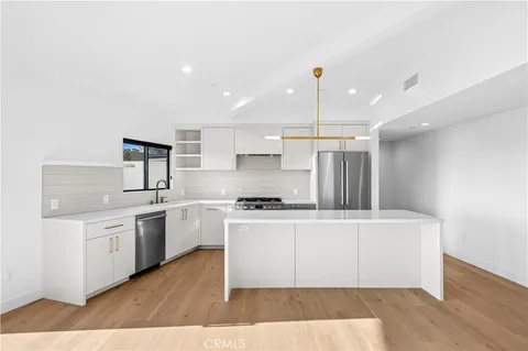 a kitchen with stainless steel appliances kitchen island a sink stove and cabinets