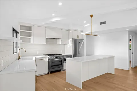 a kitchen with a sink a refrigerator and a stove top oven