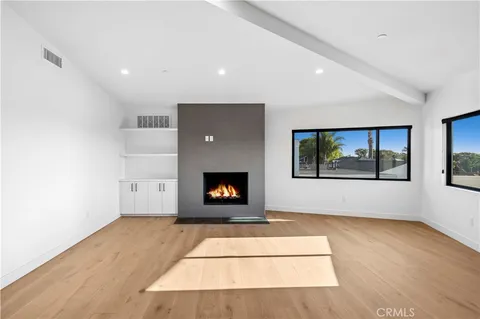 a living room with a fireplace and a floor to ceiling window
