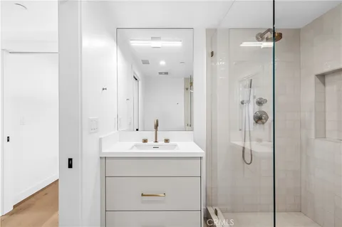 a bathroom with a sink shower and a mirror