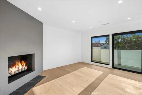 a view of an empty room with a window and fire place
