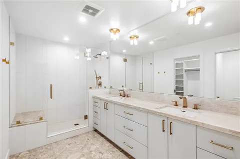 a bathroom with a shower sink double vanity and mirror