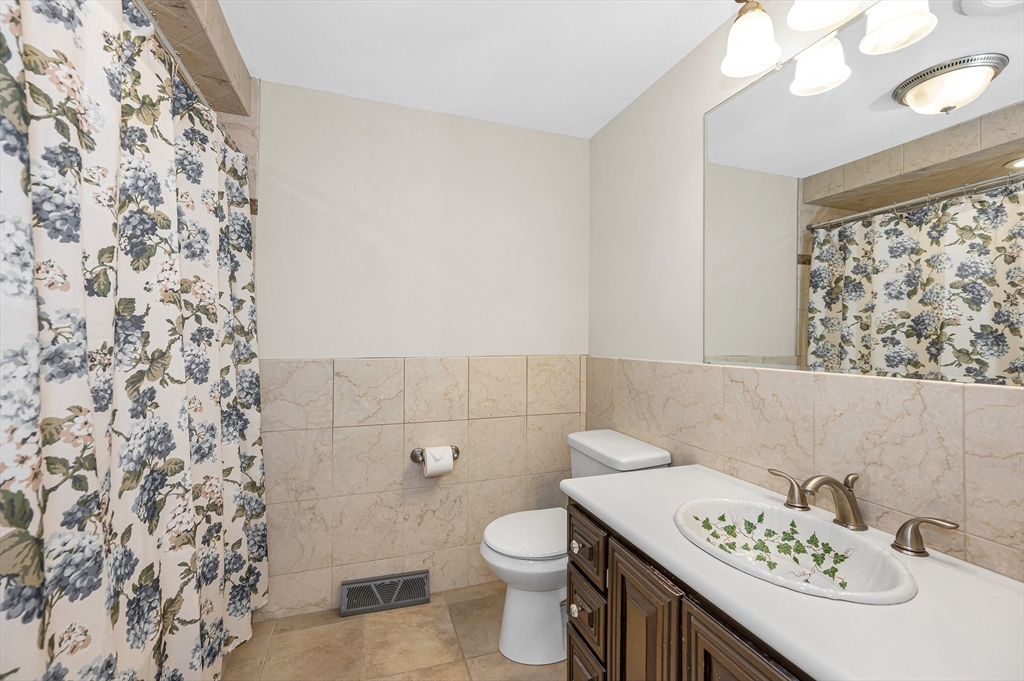 454 Dunstable Road Tyngsborough, MA 01879 - Photo 14 of 41 a bathroom with a sink a toilet and a mirror