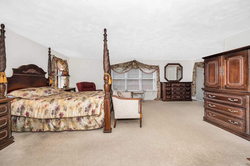454 Dunstable Road Tyngsborough, MA 01879 - Photo 20 of 41 a bedroom with bed and dresser with mirror