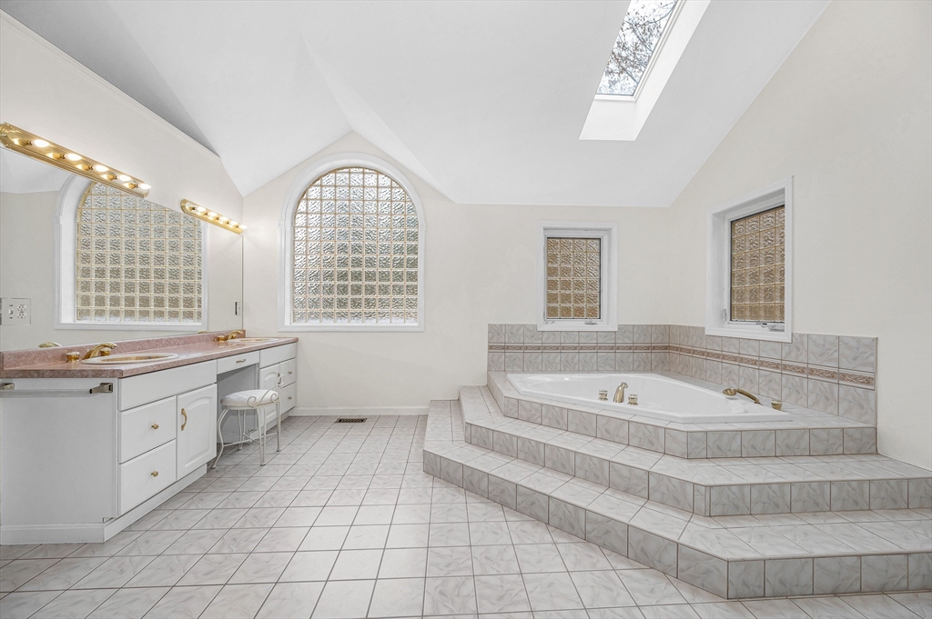 454 Dunstable Road Tyngsborough, MA 01879 - Photo 22 of 41 a spacious bathroom with a tub double sink window and mirror