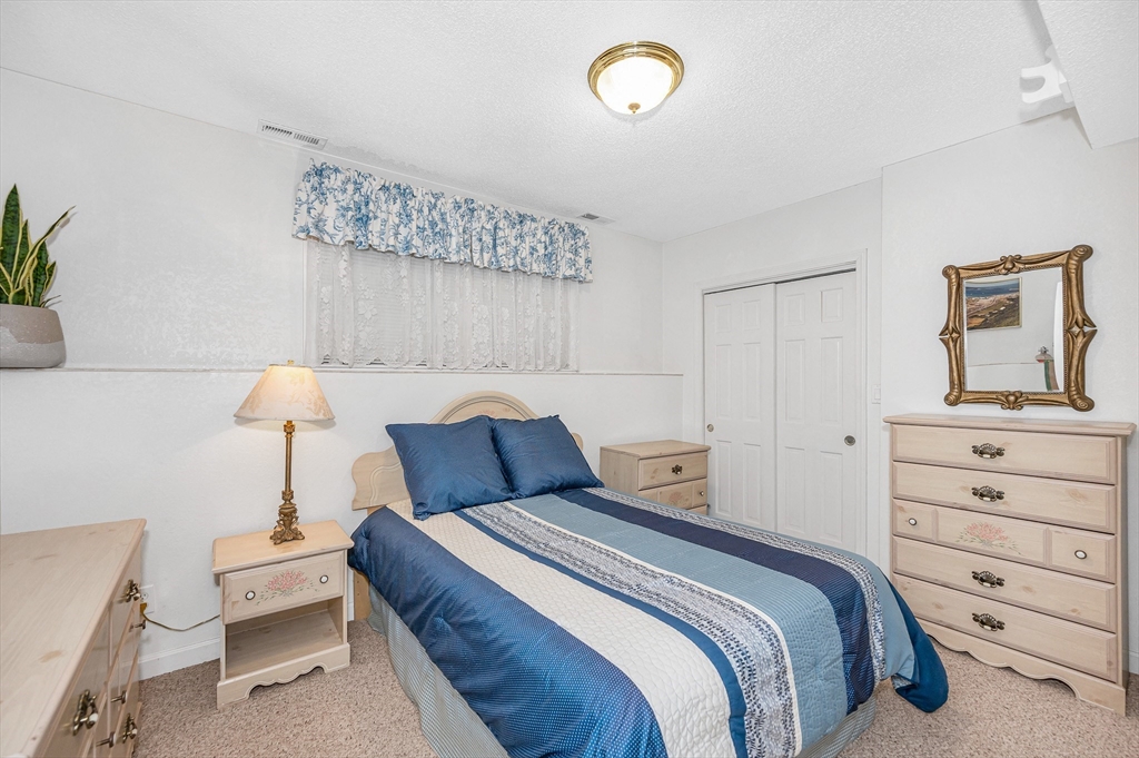 454 Dunstable Road Tyngsborough, MA 01879 - Photo 27 of 41 a bedroom with a bed and a lamp