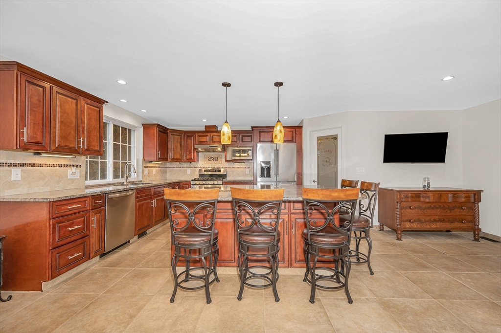 454 Dunstable Road Tyngsborough, MA 01879 - Photo 8 of 41 a kitchen with stainless steel appliances kitchen island granite countertop a table and chairs
