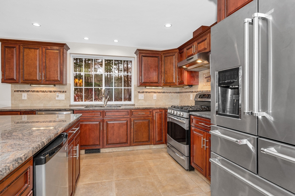 454 Dunstable Road Tyngsborough, MA 01879 - Photo 9 of 41 a kitchen with stainless steel appliances granite countertop a stove sink and cabinets