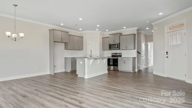 a view of kitchen view wooden floor cabinets and stainless steel appliances