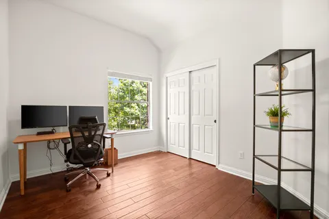 a view of a workspace with furniture and a window