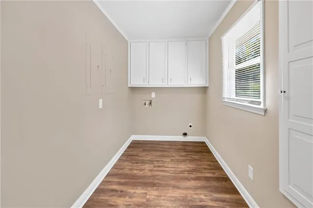 a view of a kitchen with white wooden cabinets and a window