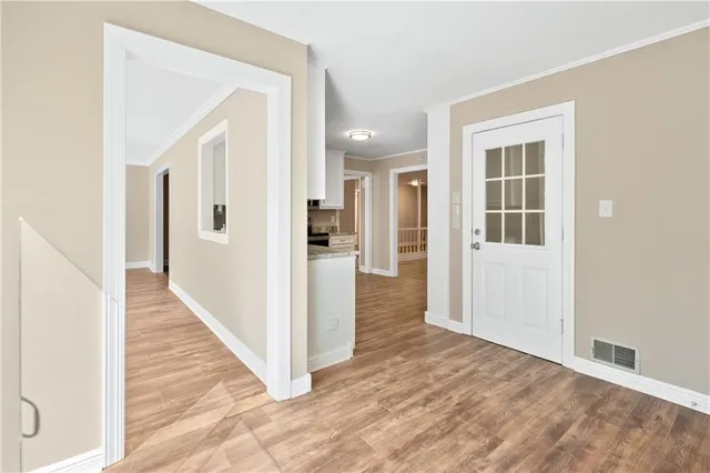 a view of a hallway with wooden floor and entryway