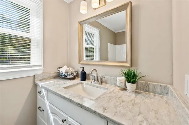 a bathroom with a granite countertop sink and a mirror