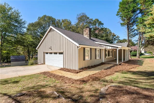 a view of a grey house with a yard