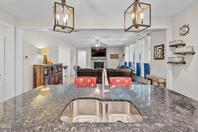 a kitchen with stainless steel appliances granite countertop a sink dishwasher and cabinets with wooden floor