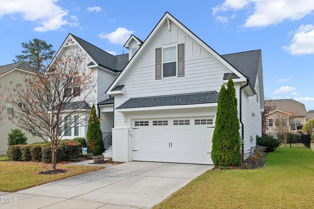 a view of a white house with a large windows and a yard