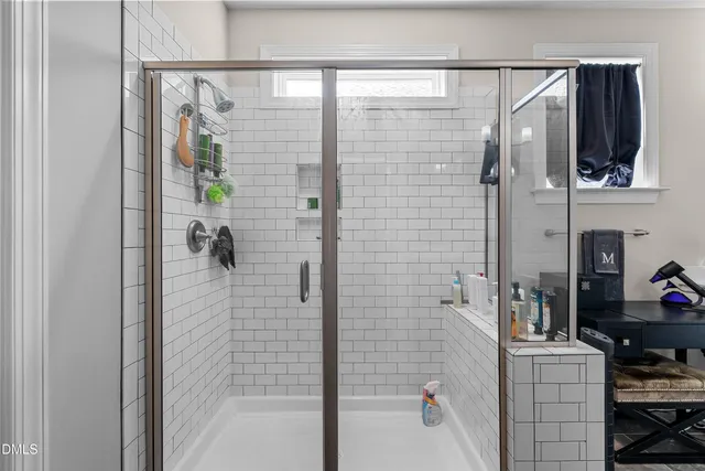 a spacious bathroom with a double vanity sink a mirror and shower