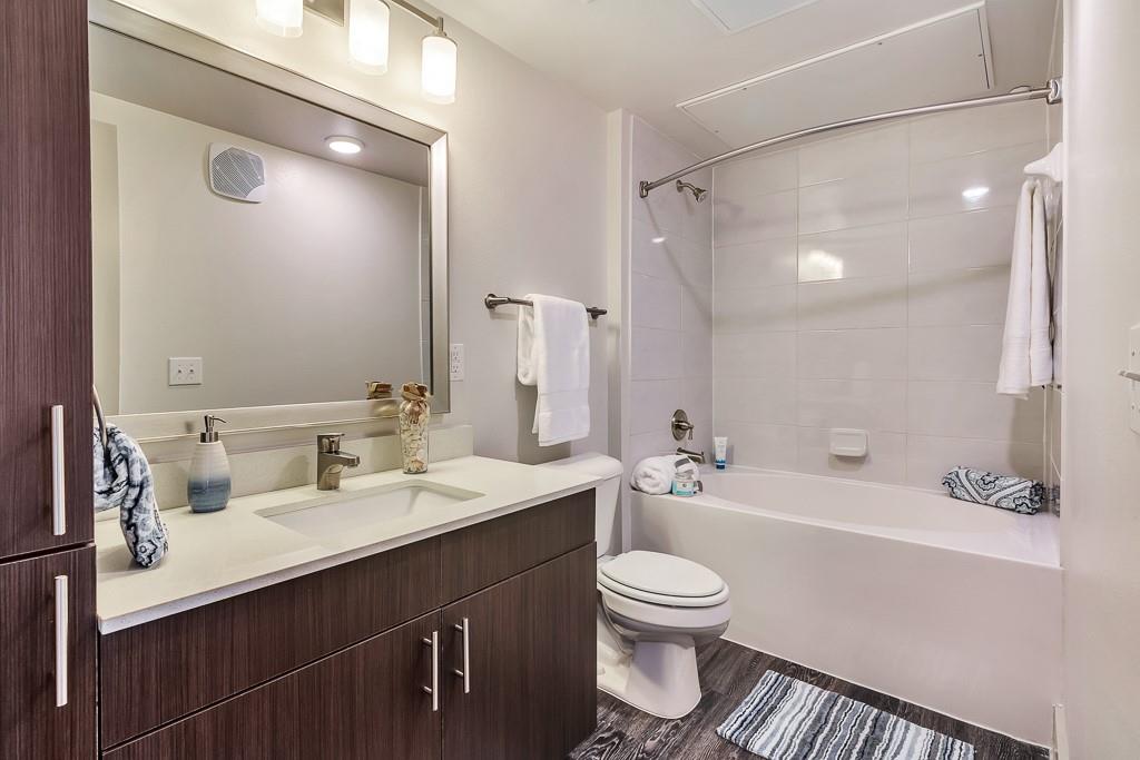 10550 North Central Expressway, Unit 161 Dallas, TX 75231 - Photo 6 of 9 a bathroom with a sink a toilet a mirror and shower