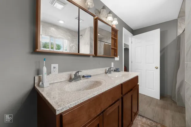 a bathroom with a granite countertop sink and a mirror