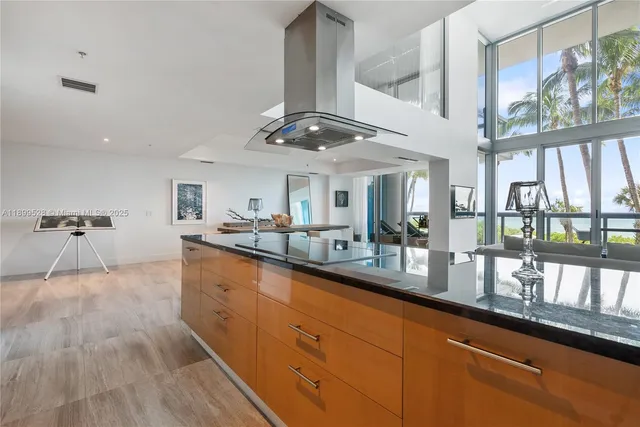 a large kitchen with stainless steel appliances granite countertop a lot of counter space and a wooden floors