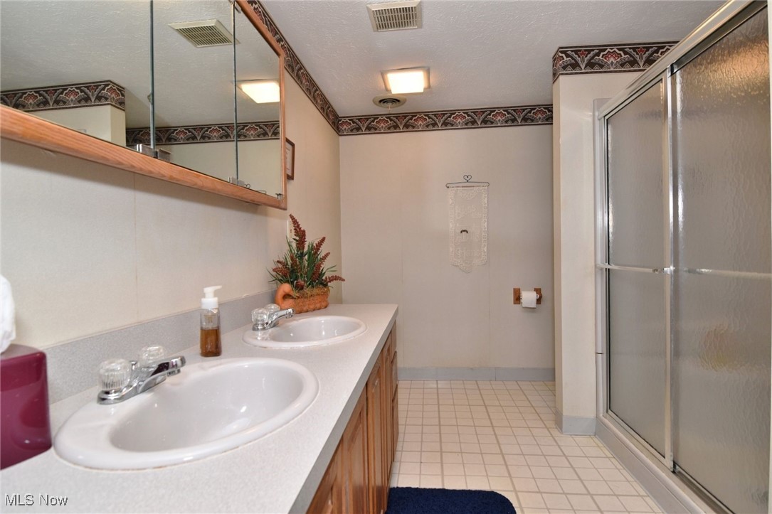 5510 Som Center Road Solon, OH 44139 - Photo 33 of 38 Lower level Full bath with a shower stall, tile patterned floors, and double vanity