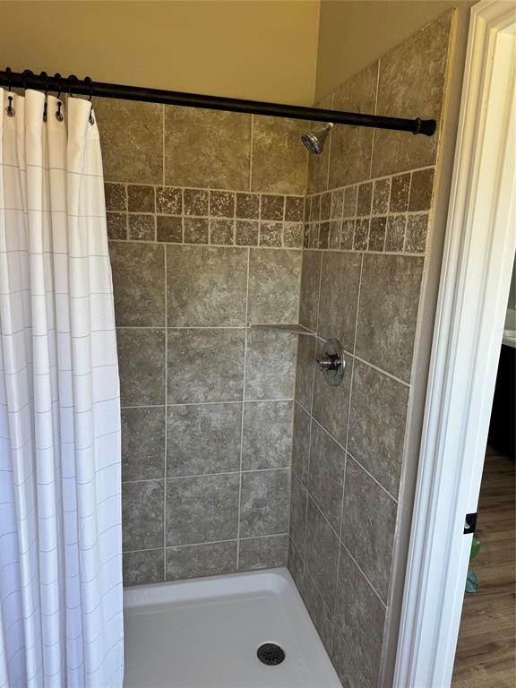 131 Lipan Trail Weatherford, TX 76087 - Photo 18 of 25 a bathroom with a shower and a bath tub